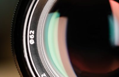 High-resolution close-up of a professional 56mm f/1.2 camera lens on a wooden surface.